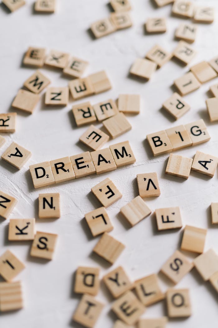 Close-Up Shot of Scrabble Tiles on a White Surface